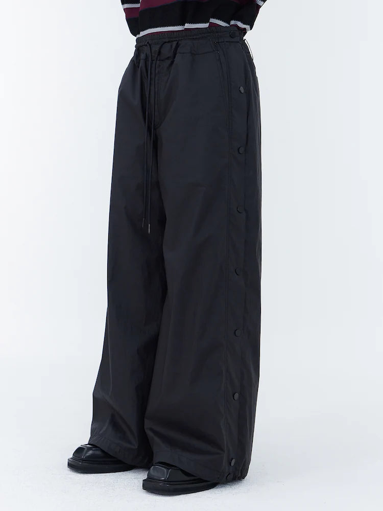 PANTALONES ANCHOS DE ALGODÓN CON BOTONES A PRESIÓN LATERALES Y CÁLIDOS NEGROS
