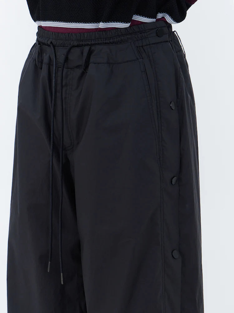 PANTALONES ANCHOS DE ALGODÓN CON BOTONES A PRESIÓN LATERALES Y CÁLIDOS NEGROS